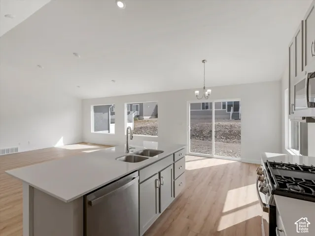 Spacious kitchen island with a double basin sink, stainless steel dishwasher, and quartz countertop
