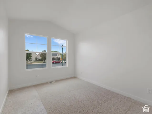 Vaulted ceiling, dual pane windows, neutral wall color, light-toned carpeting, white trim