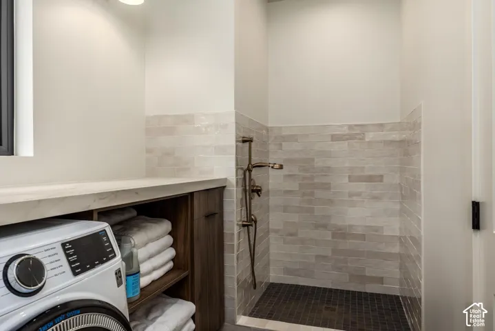 Walk-in shower with bronze fixtures and tile surround