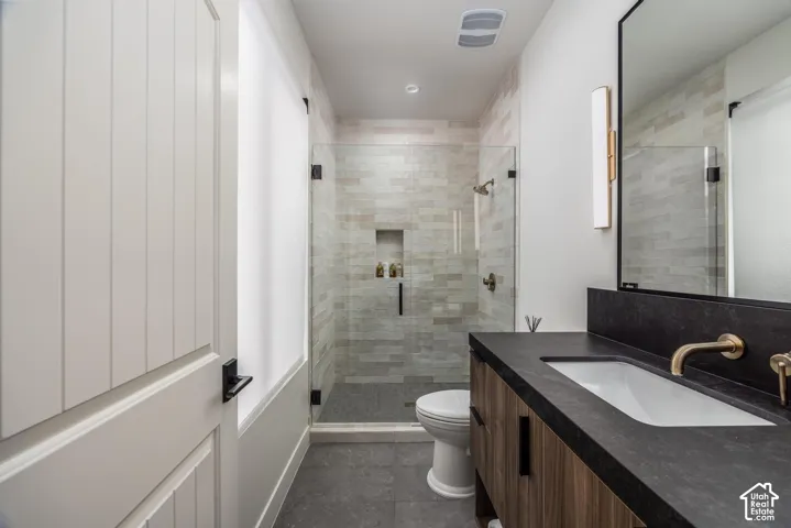 Glass-enclosed shower with tiled walls and built-in niche