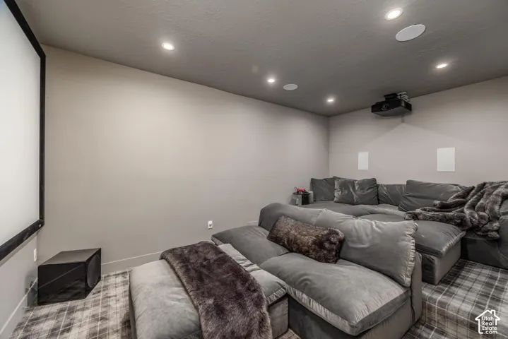 Dedicated media room featuring a large projection screen and ceiling-mounted projector