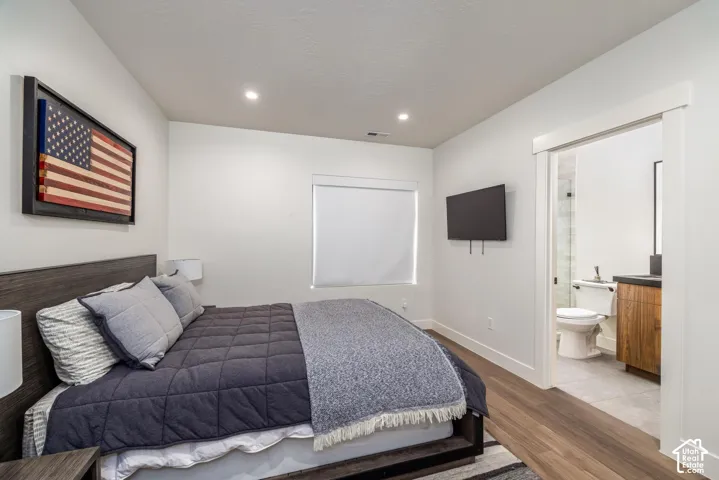 Recessed ceiling lighting, wood-finish flooring, and a sliding barn door