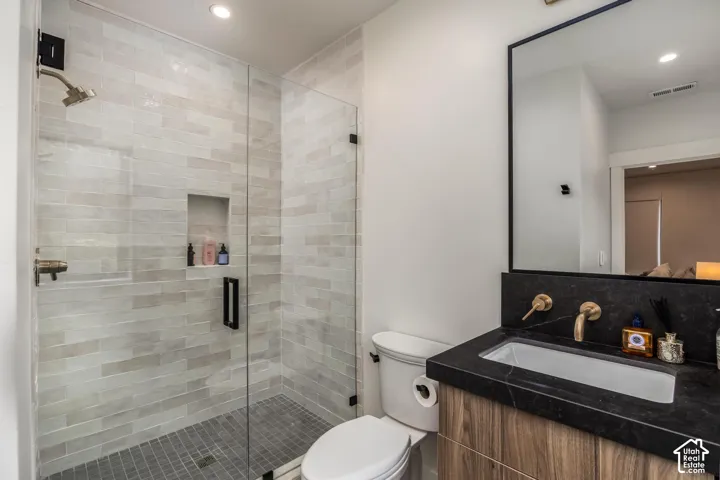 Glass-enclosed shower with horizontal tile surround and recessed niche