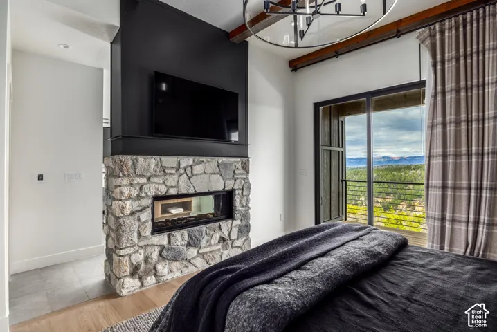 Stone-clad fireplace with an integrated linear firebox, wood-finish flooring, and a large sliding glass door opening to a balcony