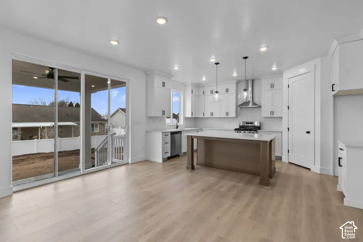 Contemporary kitchen featuring white cabinetry, stainless steel appliances, a wood-finish island, and recessed lighting