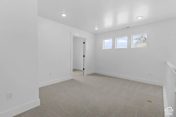 Neutral-toned carpeting, recessed ceiling lighting, three transom windows, white wall finishes, and a white handrail