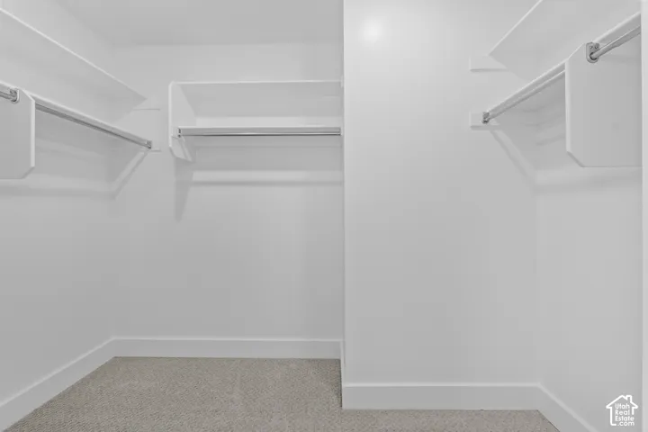 White shelving system with chrome hanging rods and light-toned carpet flooring