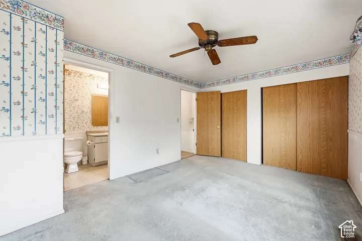 Ceiling fan with wooden blades, two wooden doors, and two sliding wooden closet doors