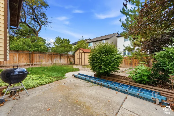 Expansive concrete patio with a wooden privacy fence