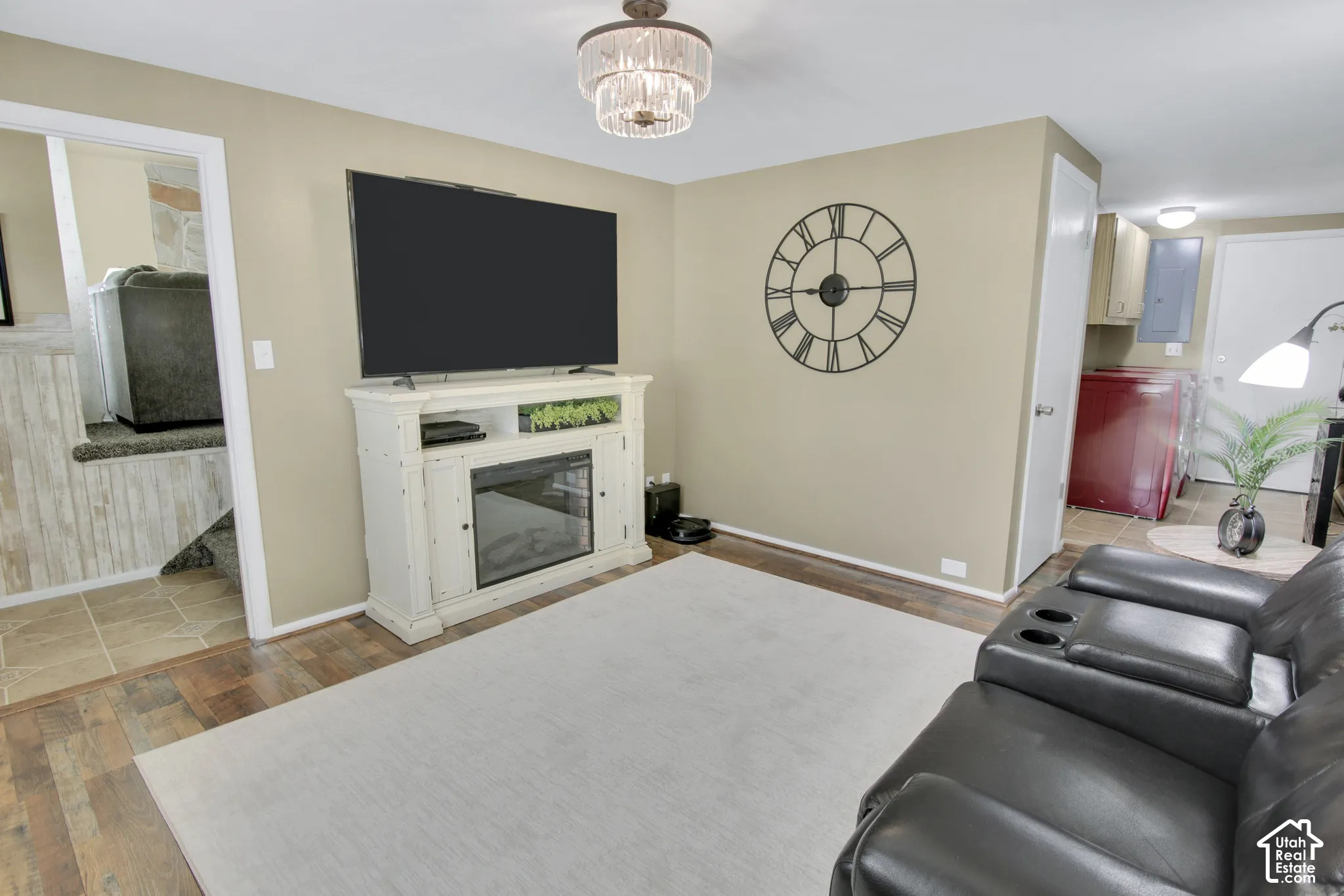 Wood-finish flooring with neutral wall paint and a tiered chandelier