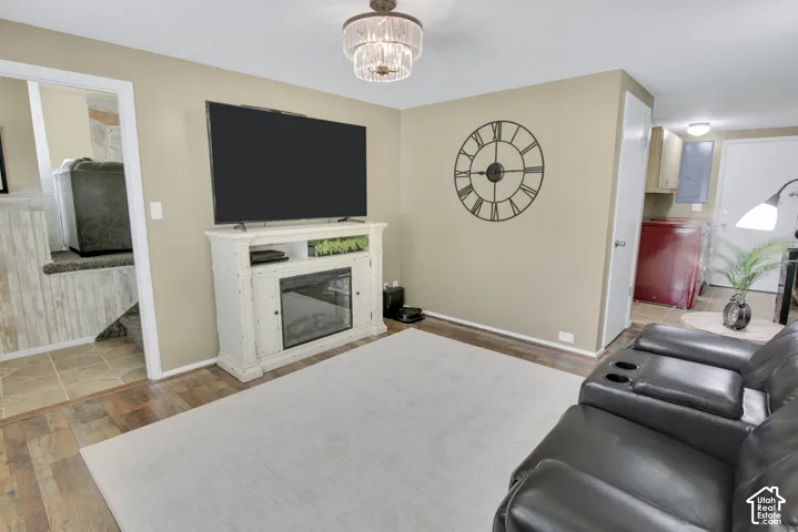 Wood-finish flooring with neutral wall paint and a tiered chandelier