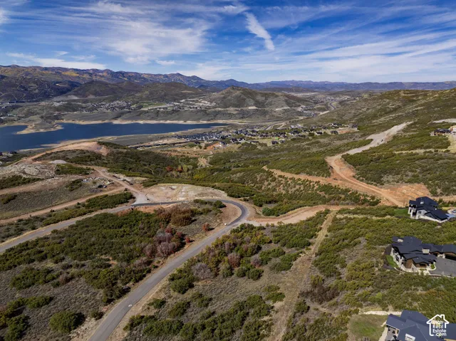 Expansive landscape featuring a lake, surrounding mountains, and residential developments