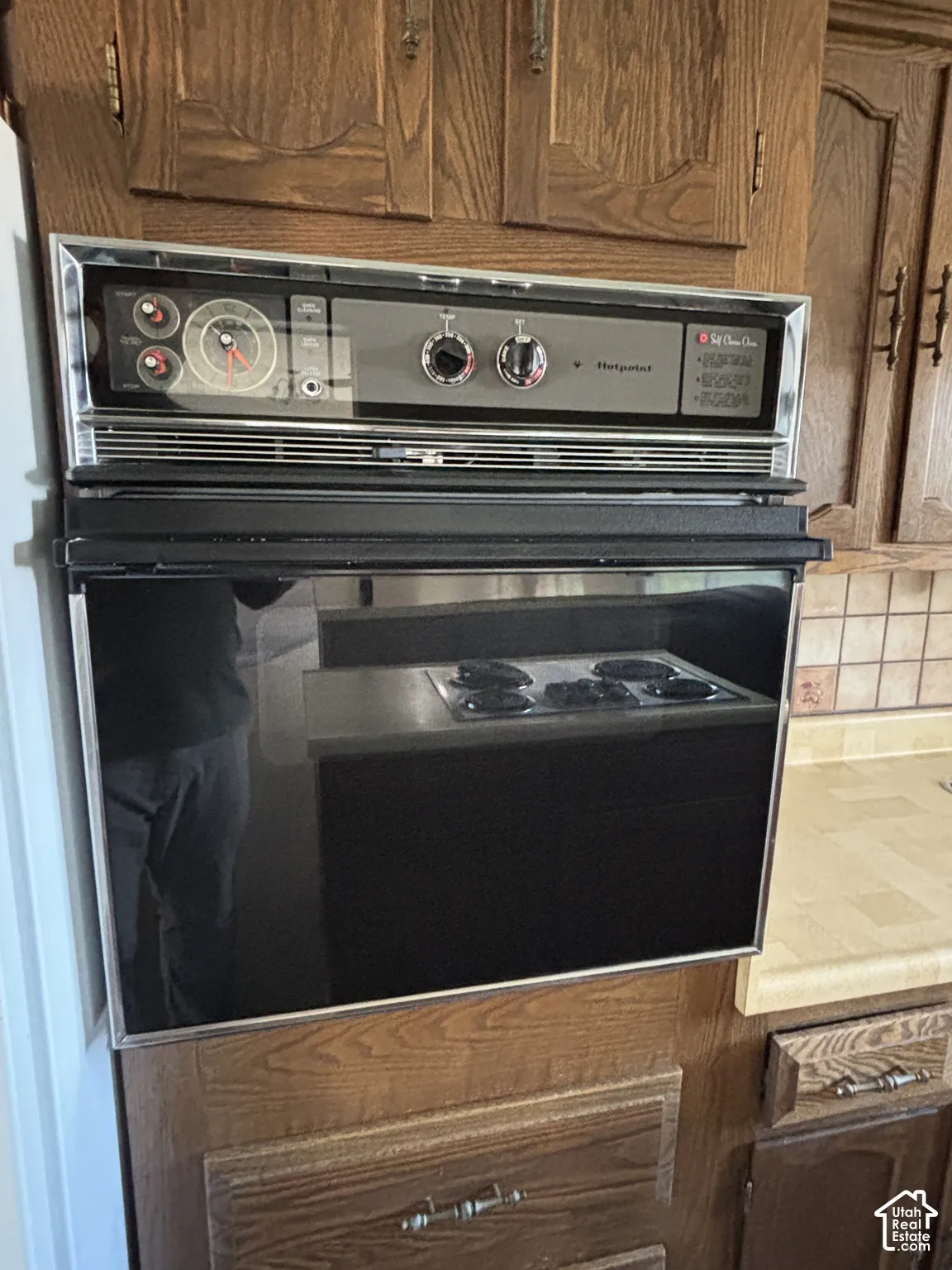 Built-in wall oven with a black glass door, stainless steel trim, and control panel
