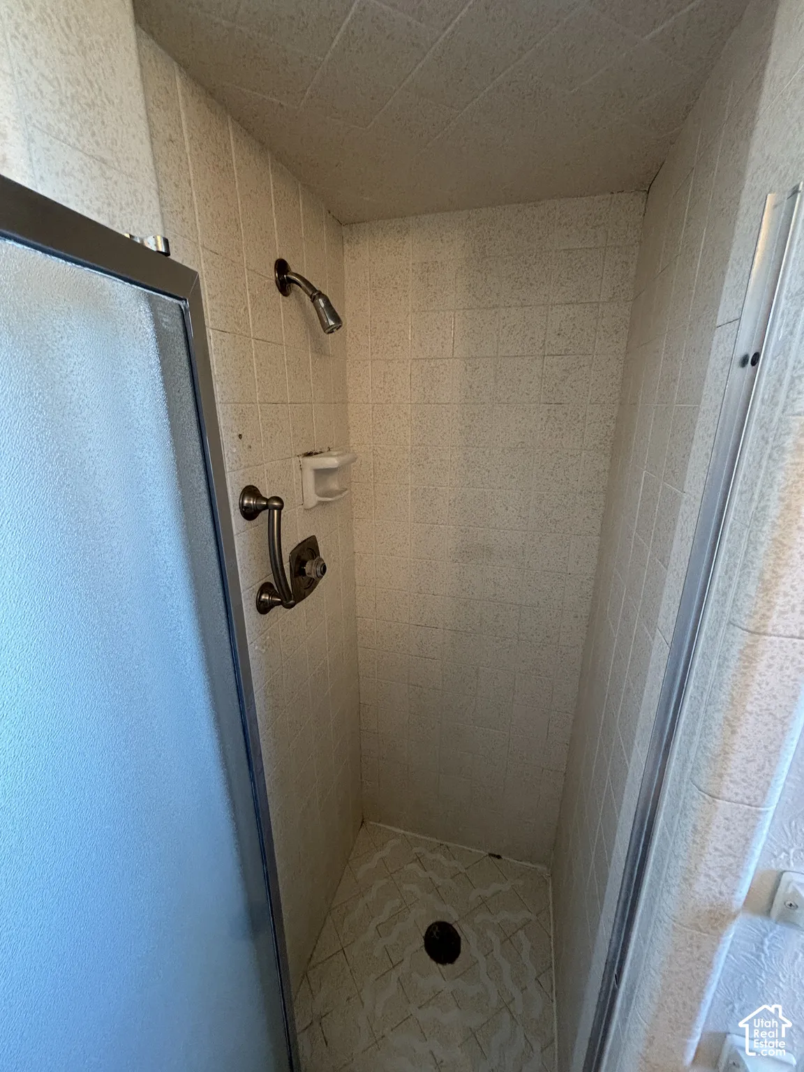 Tiled shower enclosure with a clear glass door