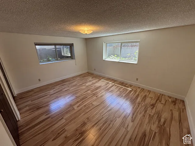 Wood-finish flooring throughout, light neutral wall tones, and two windows