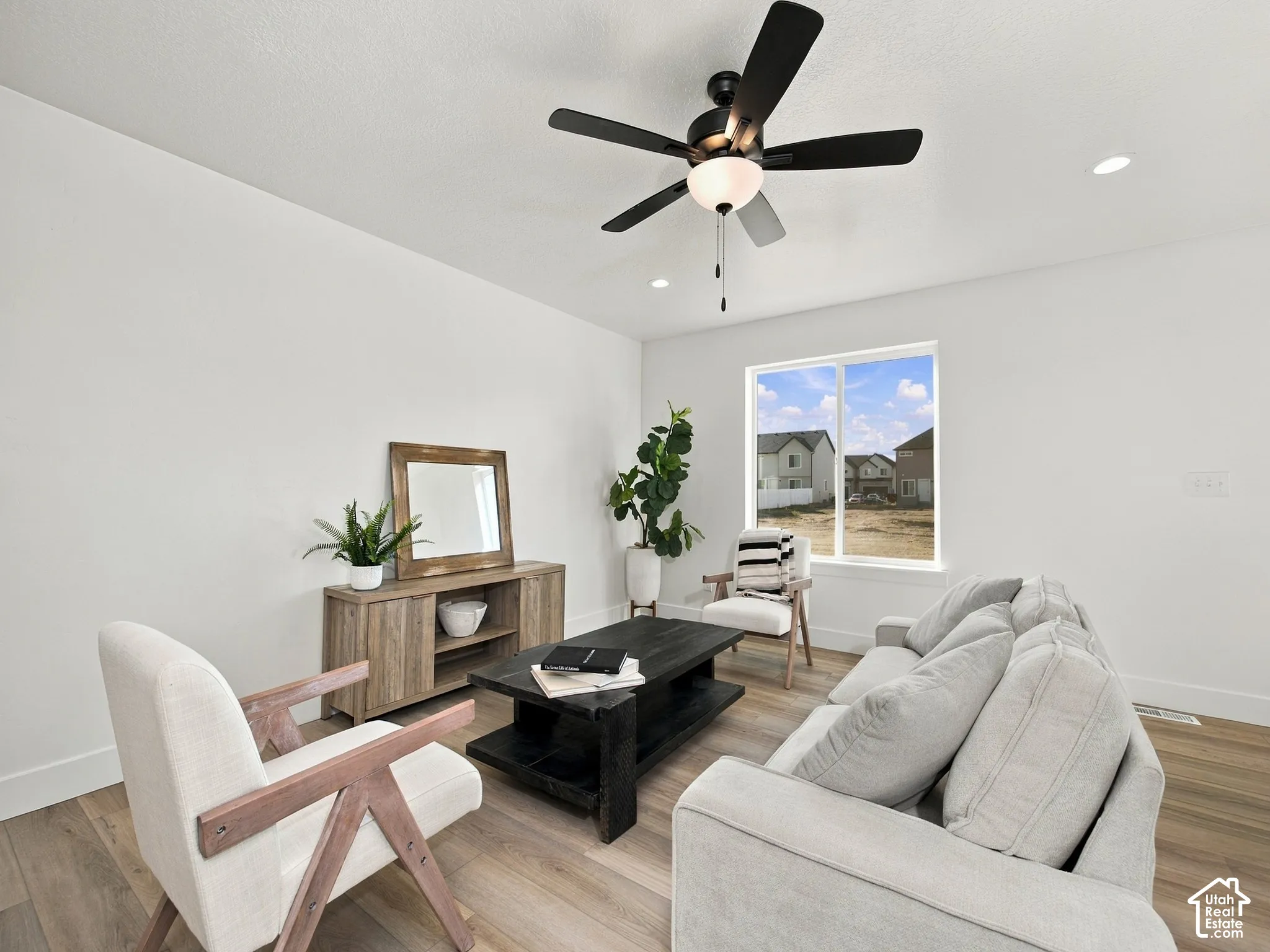 Recessed lighting, a modern ceiling fan, wood-finish flooring, and a large window