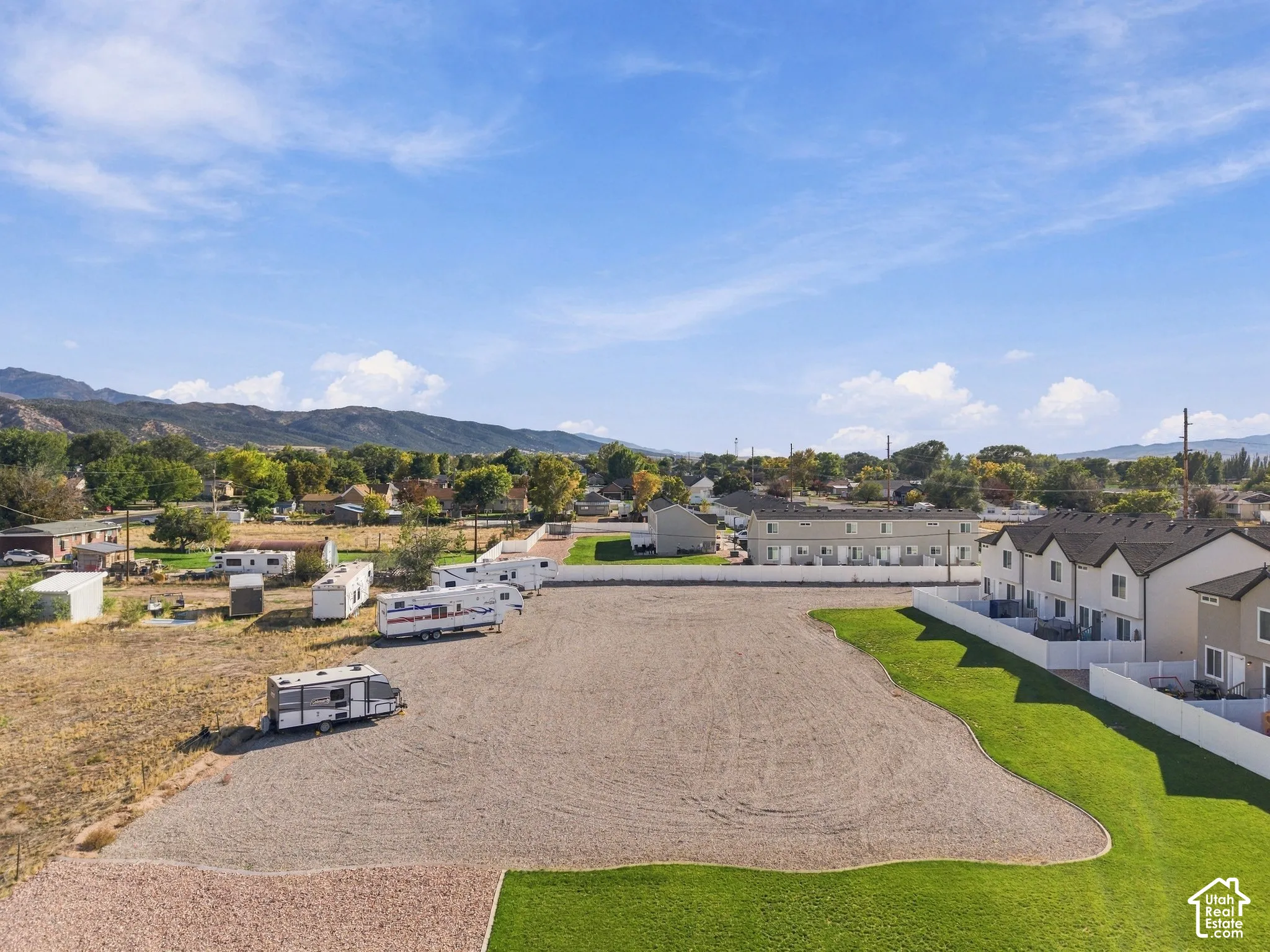Expansive gravel lot for RV parking with surrounding green landscaping