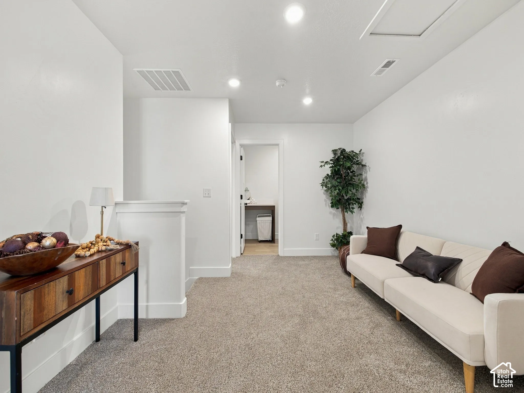 Recessed lighting, carpet flooring, interior railing, white wall paint, accessible attic hatch