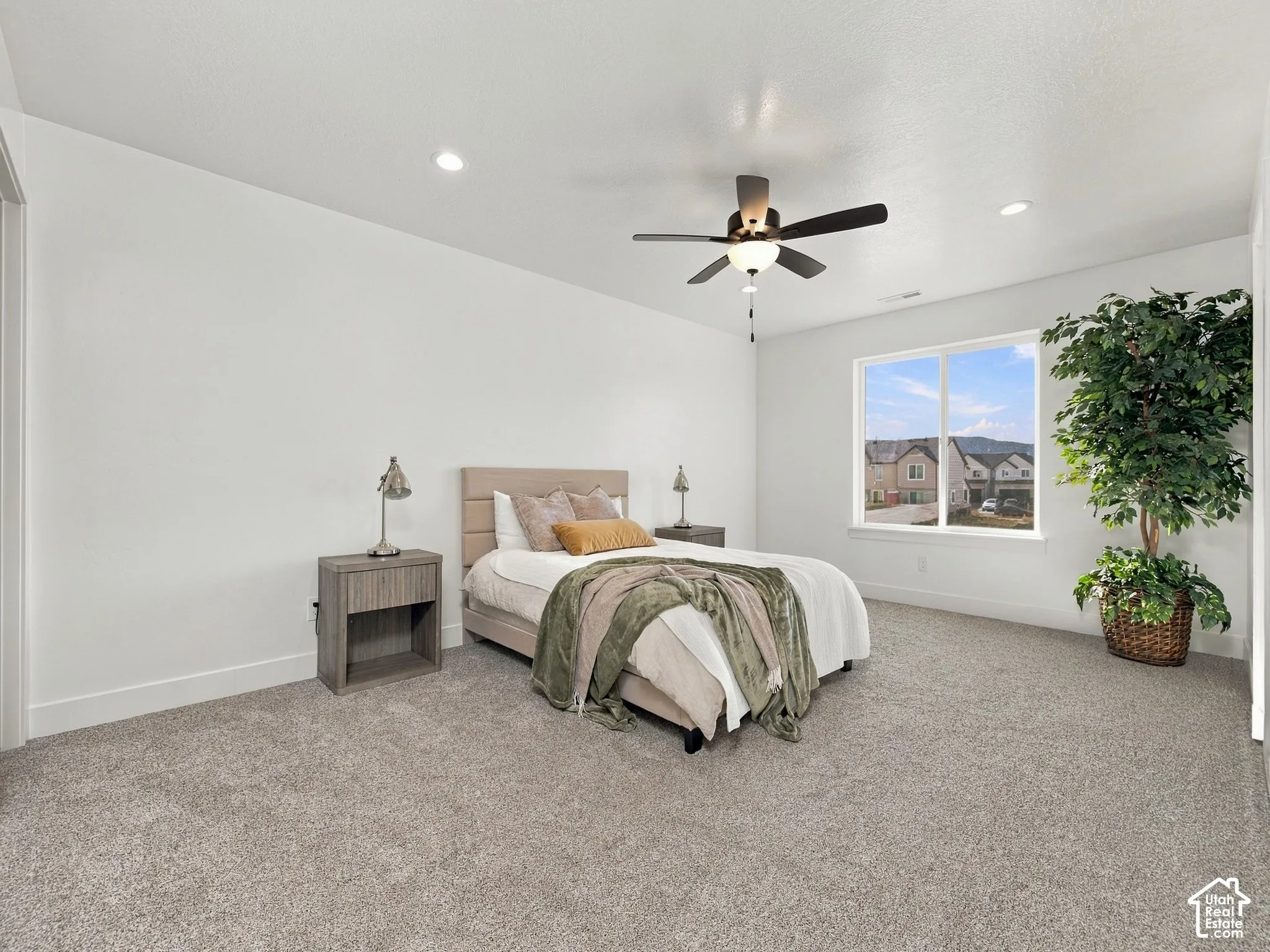 Spacious room with plush carpeting, recessed lighting, and a modern ceiling fan