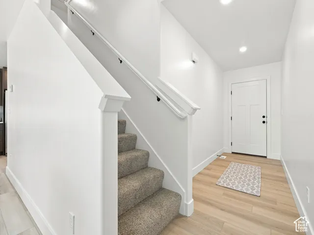 Staircase with carpeted treads and white wood railing