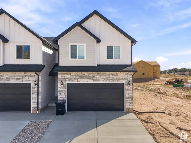 Modern exterior design featuring light-toned stacked stone, vertical siding, and contrasting dark trim