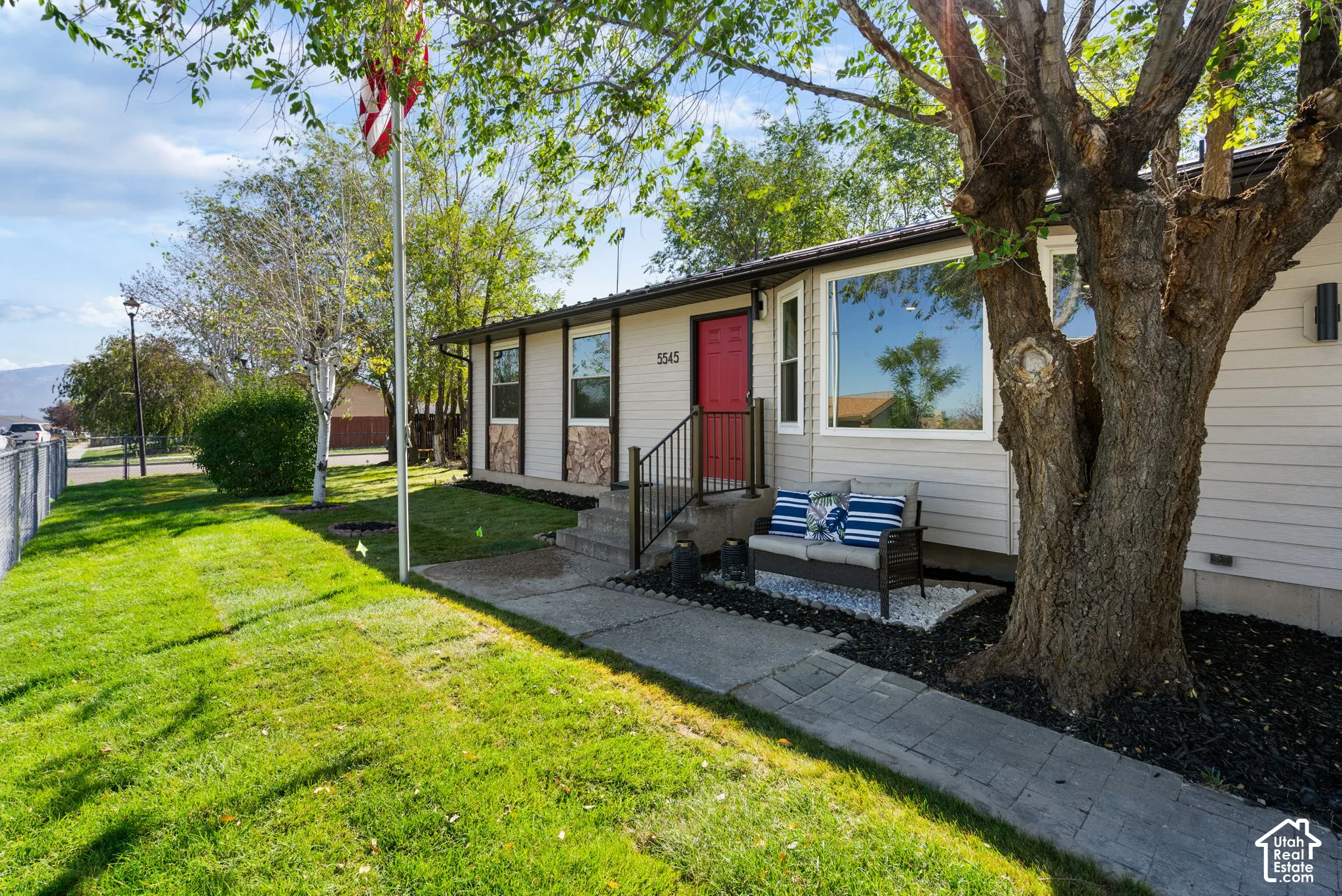 another view of home, new sod and sprinkler system, fully fenced with flag pole.