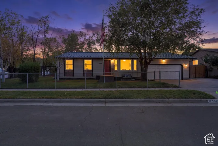 fully fenced, view of home at dusk
