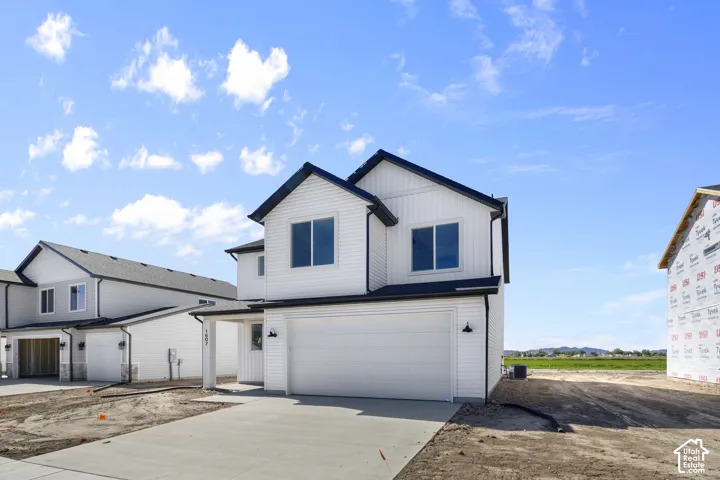 Contemporary two-story exterior with white siding, black trim, and a prominent two-car garage