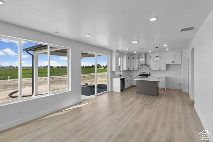 Open-concept living area with wood-finish flooring, recessed lighting, and large windows
