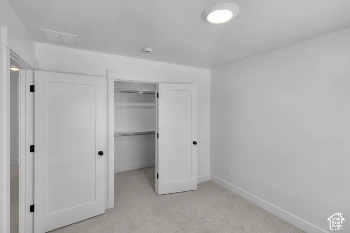 Built-in closet with double doors, carpeted flooring, and recessed ceiling lighting
