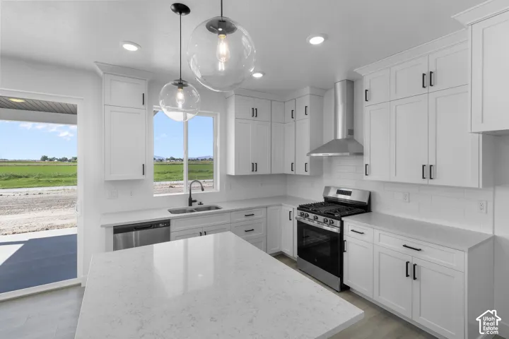 White shaker cabinetry, stainless steel appliances, quartz countertops, subway tile backsplash, and light wood-finish flooring