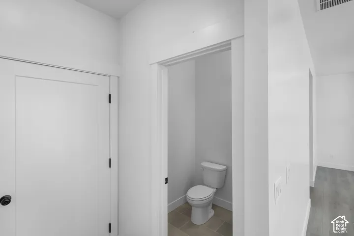 White flat-panel door with black hardware, white trim, and light tile flooring