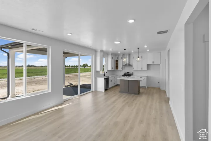 Open-concept living space with wood-finish flooring, recessed lighting, and large windows