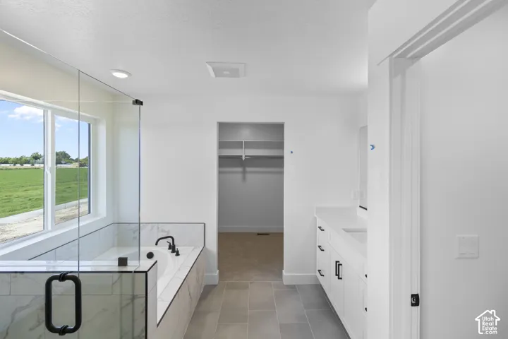 Built-in bathtub with black fixtures and a glass shower enclosure