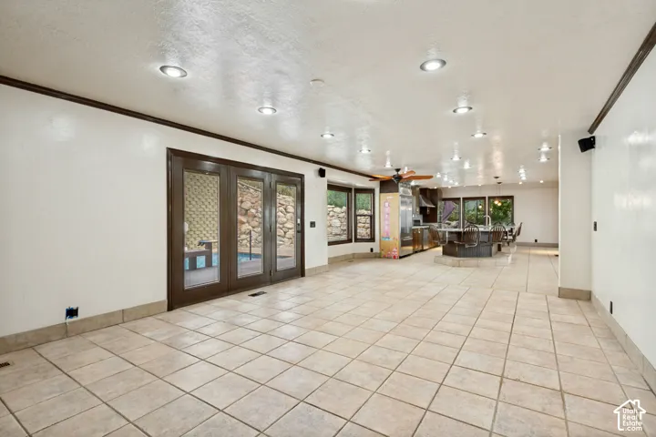 Spacious open-concept room with tile flooring, recessed lighting, and dark wood trim