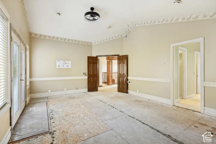 Vaulted ceiling, decorative crown molding, chair rail molding, double glass-paneled doors, paneled wood doors