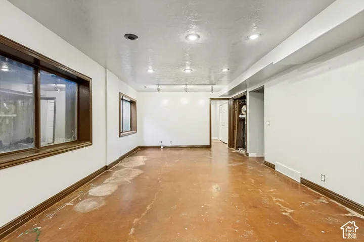 Recessed ceiling lighting, brown window trim, and baseboards