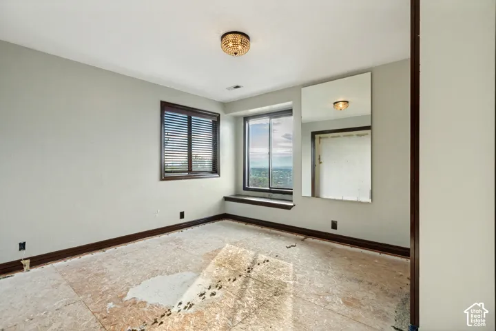 Hardwood window trim with blinds, built-in window seat, ceiling-mounted light fixture, and wall-mounted mirror