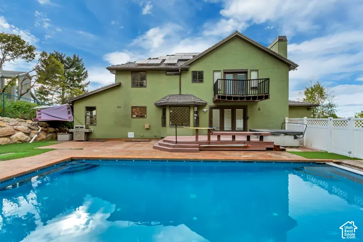 In-ground swimming pool, expansive patio, private balcony, solar panels, and a spa