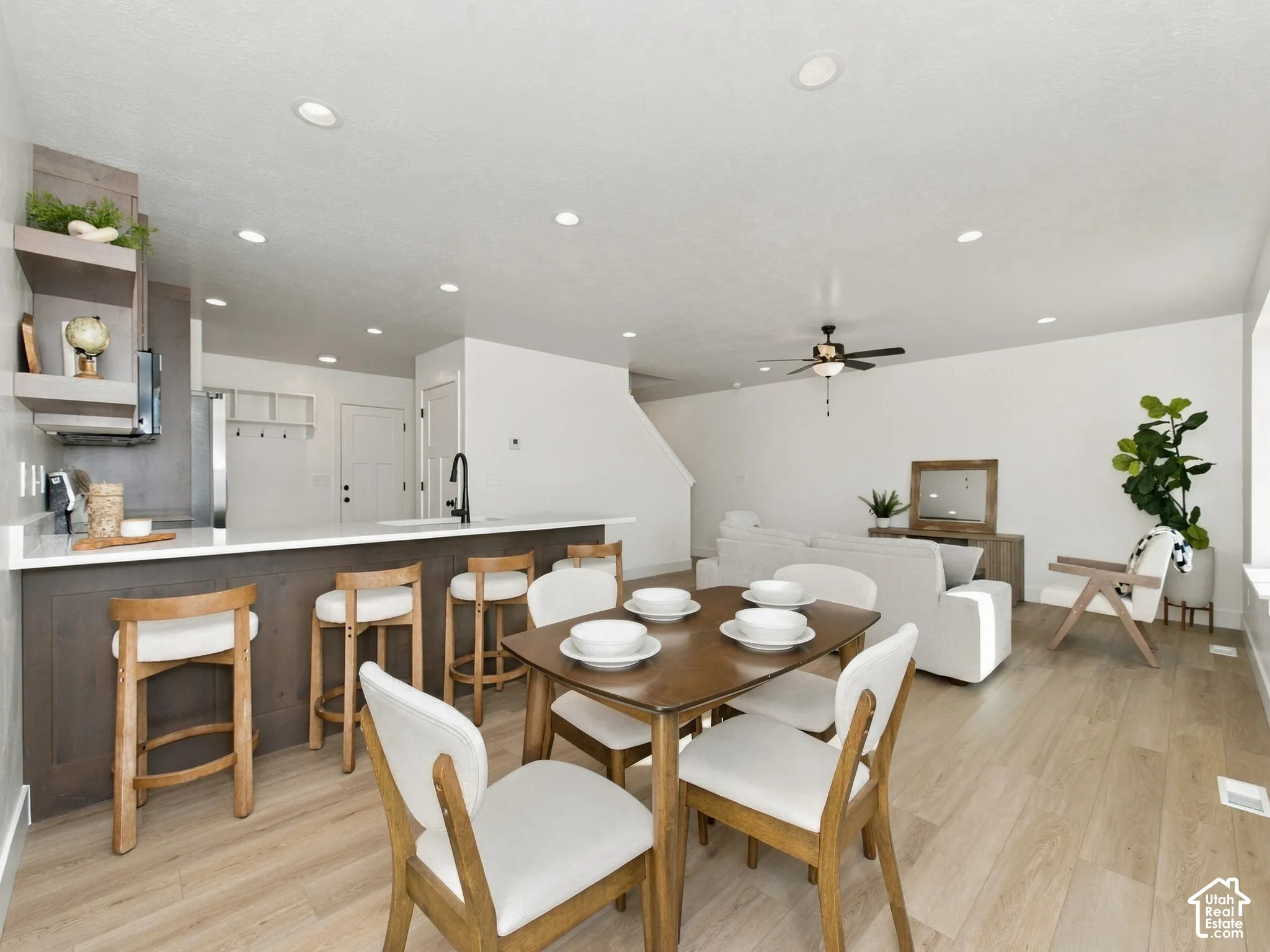 Open-concept living space featuring wood-finish flooring, recessed lighting, and a ceiling fan