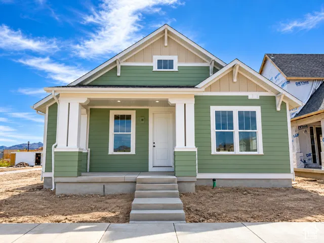 Craftsman-style exterior with green siding and tan gable accents