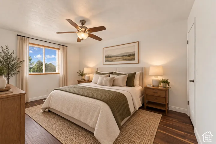 Rich wood-finish flooring, ceiling fan with integrated lighting, and a white paneled door
