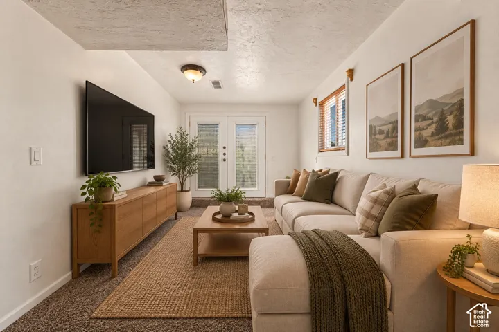 Recessed lighting, wood-finish media console, double French doors, wood-finish window blinds, and overhead lighting fixture