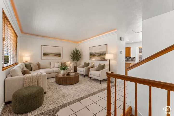 Living area with crown molding, natural wood window trim, and recessed lighting