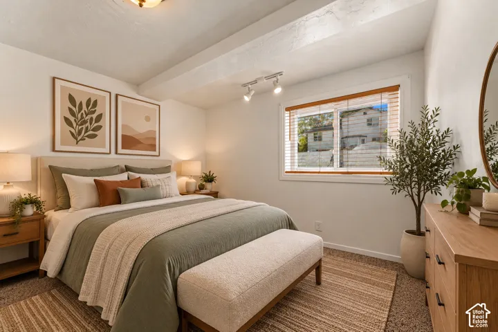 Window with wood-finish blinds, exposed ceiling beams, and overhead track lighting