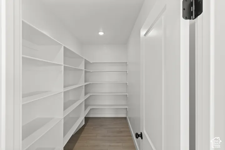 Built-in shelving, recessed lighting, wood-finish flooring, solid core door, and matte black hardware