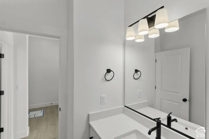 Vanity with a white countertop, undermount sink, and matte black faucet
