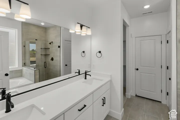 Dual vanity with white cabinetry, matte black hardware, and an expansive mirror