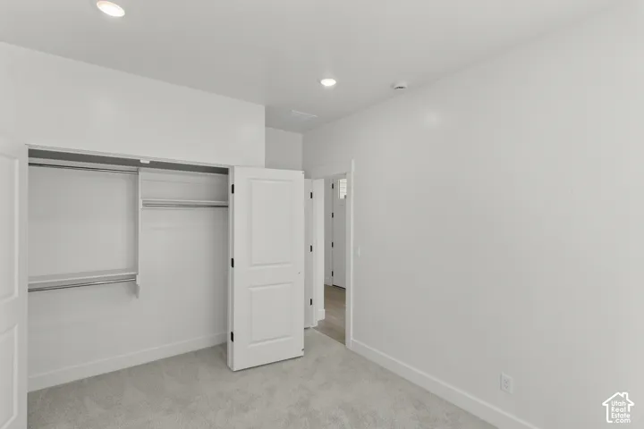 Recessed ceiling lighting with a two-panel interior door, featuring a built-in closet with shelving and hanging rods