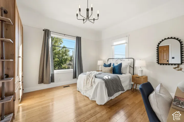Large, bright bedroom with hardwood flooring